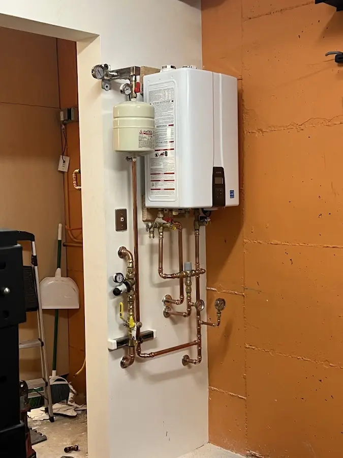 Plumbing technician inspecting water heater connections in Palmyra